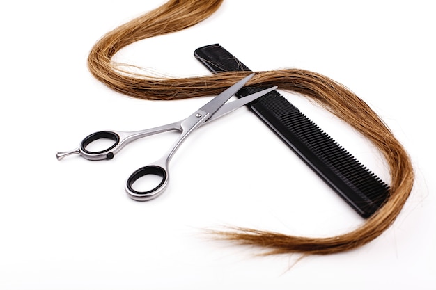 Scissors and combs for hair cut and treatment lie on a white table