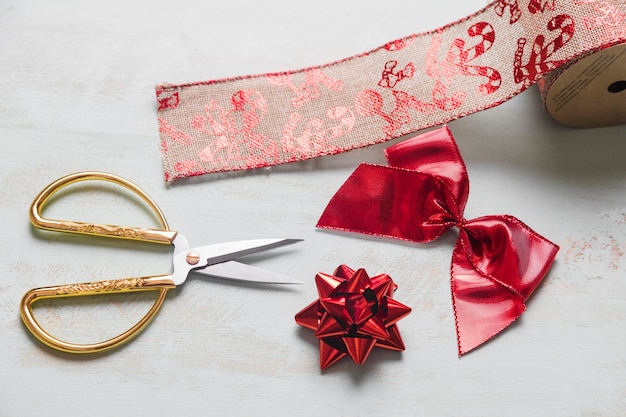 Free photo scissors near red bows and christmas ribbon