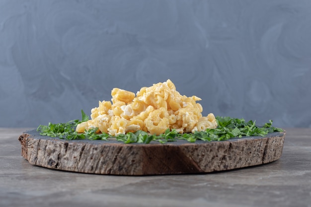 Free Photo scrambled eggs decorated with greens on wood piece.