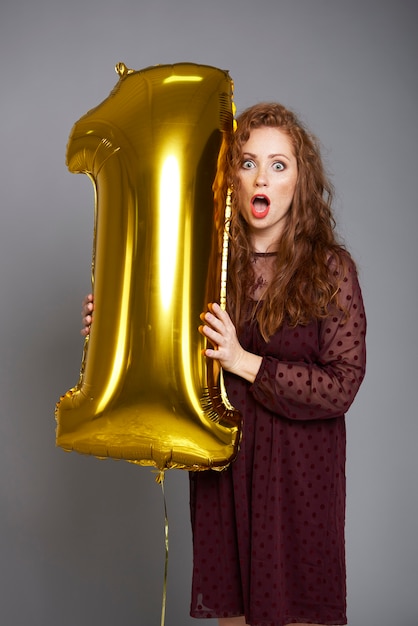 Free photo screaming woman holding golden balloon