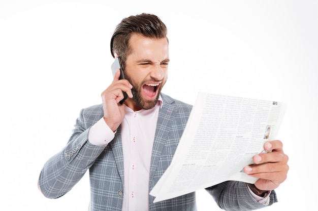 Screaming young man holding gazette and talking by phone