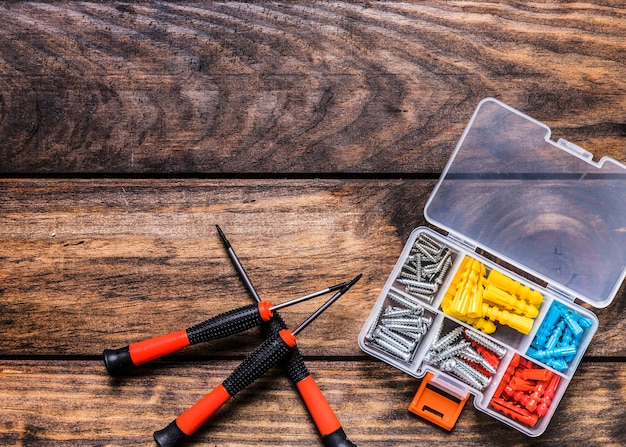 Free Photo screwdrivers with bolt kit on wooden background