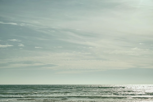 Sea on sunny cloudy sky background Beautiful cloudy spring sky on a bright sunny day Turquoise afternoon on the sandy beach of the Black Sea High quality photo