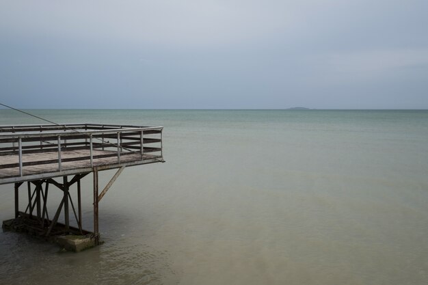 Sea water and blue sky along with wooden pier