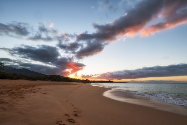 Free photo sea waves crashing on shore during sunset