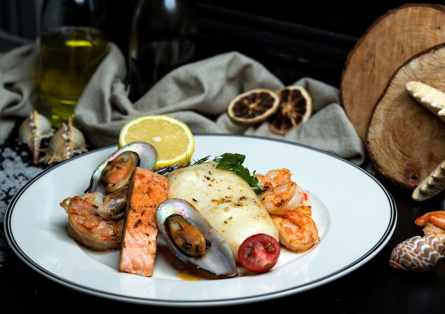 Free photo seafood plate with fried salmon, mussels, shrimps, calamari and lemon