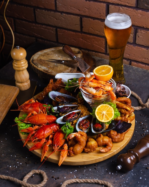 Free Photo seafood plate with shrimps, mussels, lobsters served with lemon and glass of beer