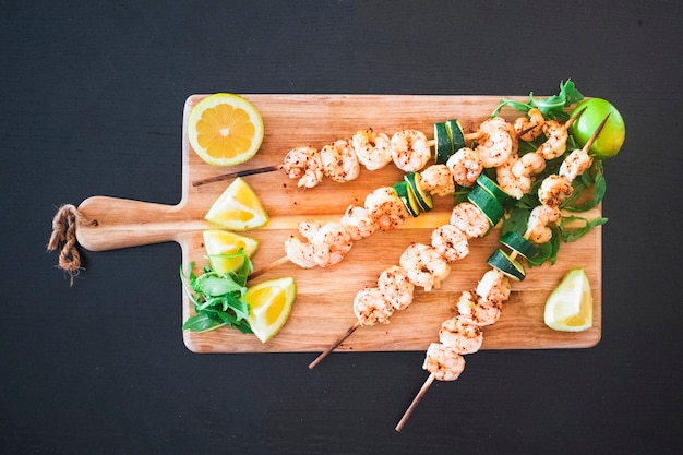 Seafood shish kebabs served with citrus fruits 