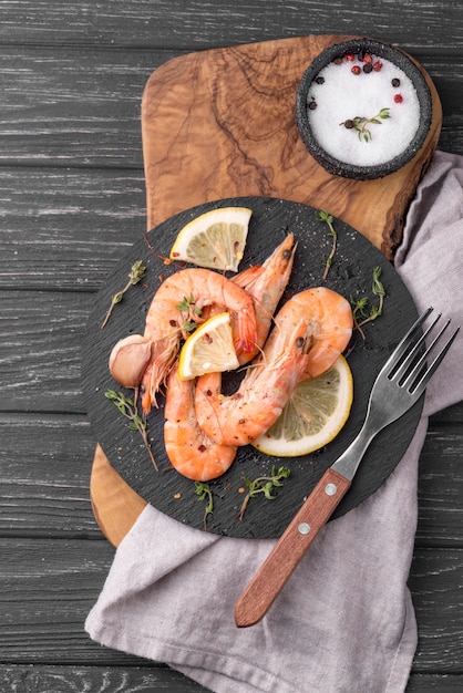 Free photo seafood shrimp on wooden board and cutlery