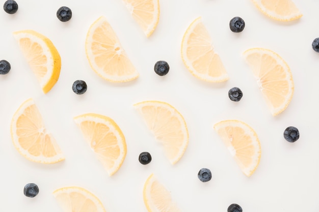 Free photo seamless pattern of blueberries and lemon slices on white backdrop