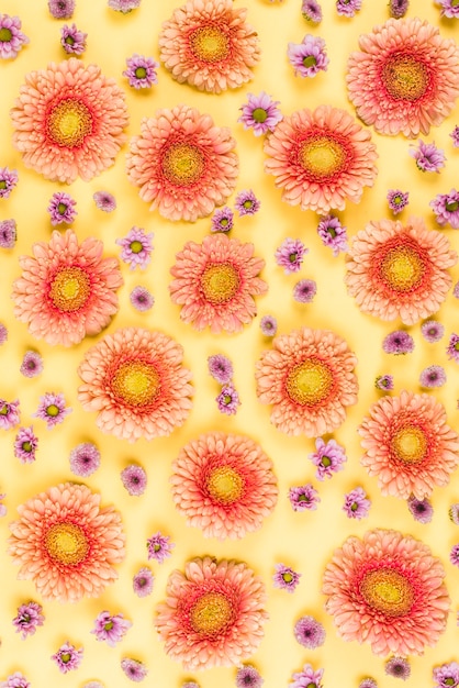 Free photo seamless pattern of large and tiny flowers on yellow backdrop