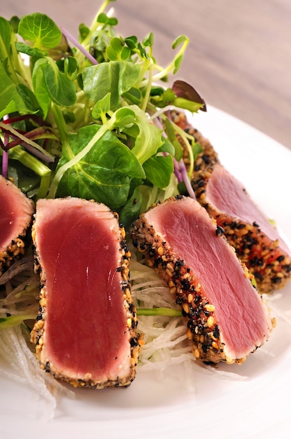 Free Photo seared tuna coated with sesame seeds close up