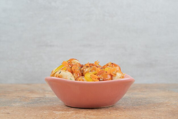 Seashell shaped pasta in bowl with tomato sauce