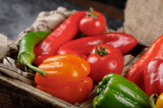 Seasonal peppers in a rustic tray. Top view.