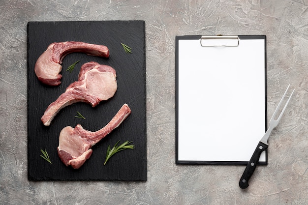 Seasoned meat on wooden board and clipboard