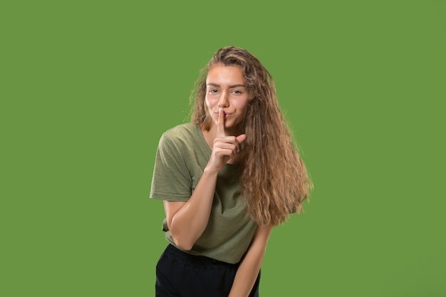 Secret, gossip concept. Young woman whispering a secret behind her hand.