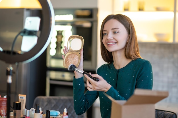 Free Photo secrets of good make up. pretty young woman in green dress showing make up tips