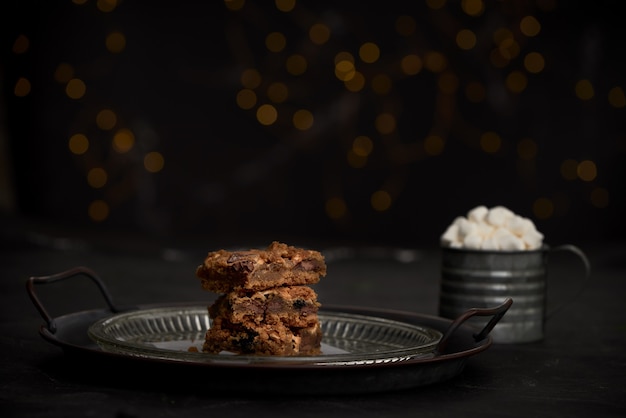 Free Photo selective focus closeup of cookies on a glass plate on the table with a cup of mallows on the side