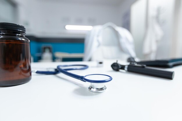 Selective focus on medical stethoscope standing on table ready for disease consultation. Empty doctor office with nobody in it equipped with professional examination tools. Medicine concept