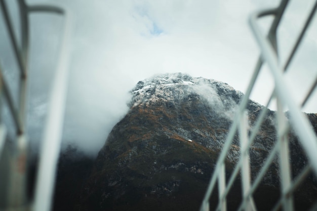 Selective focus photography of high rocky mountains covered with snow and fog