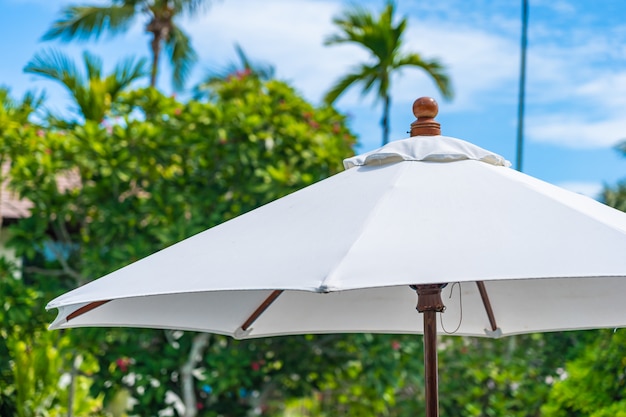 Selective focus point on umbrella with coconut palm tree on the background for holiday vacation