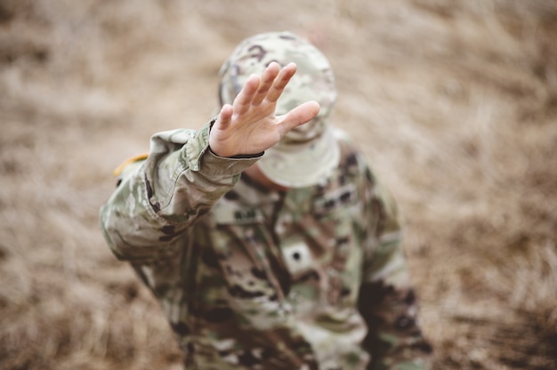 Free photo selective focus shot of an american soldier with his hand raised above