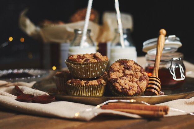 Selective focus shot of delicious Christmas cookie muffins on a plate with honey and milk