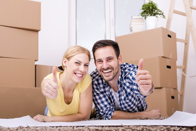 Selective focus shot of a happy white couple moving in together into a new house