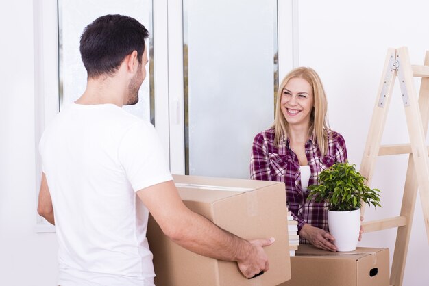 Selective focus shot of a happy white couple moving in together into a new house