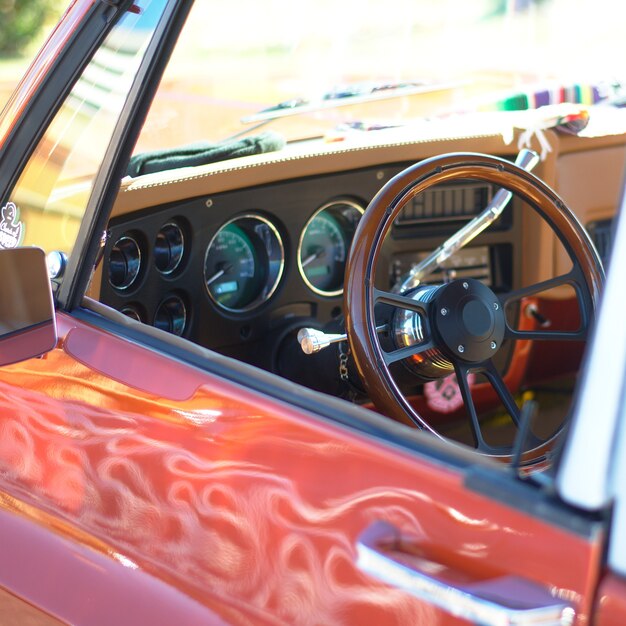 A selective focus shot of a low rider car steering wheel