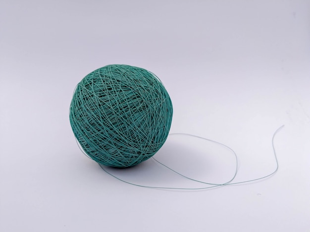 Selective focus shot of a turquoise thread yarn isolated in a white background