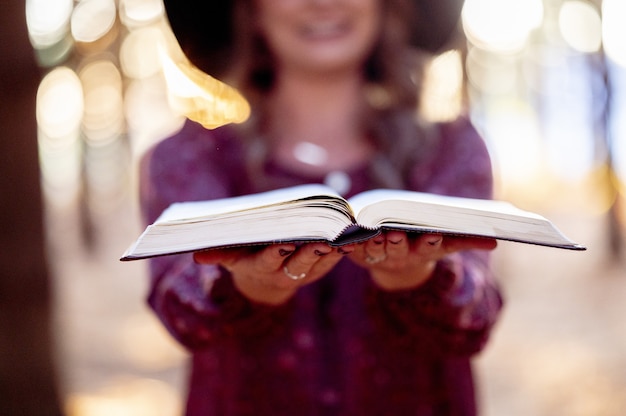 Selective focus shot of a woman holding an open book