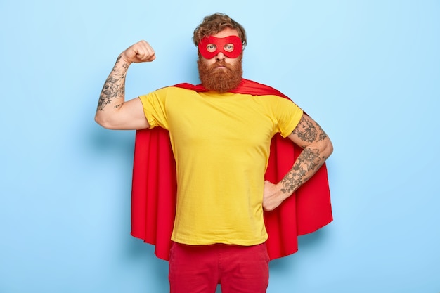 Free photo self confident superhero shows biceps, fights evil and helps people