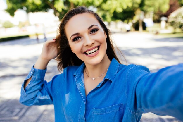 Selfie of funny attractive girl taking selfie on the street