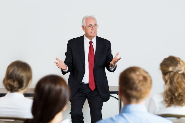 Free photo senior business man giving a lecture