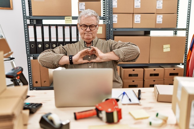 Free Photo senior caucasian man working at small business ecommerce with laptop smiling in love doing heart symbol shape with hands romantic concept