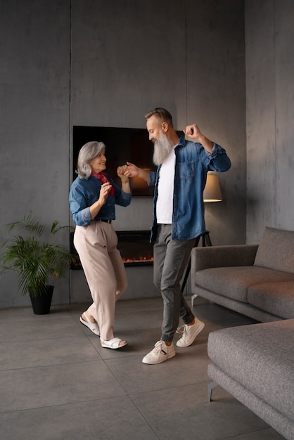 Free photo senior couple dancing at home