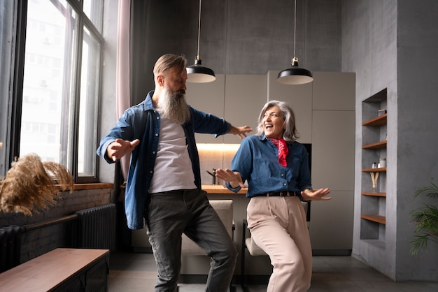 Free photo senior couple dancing at home