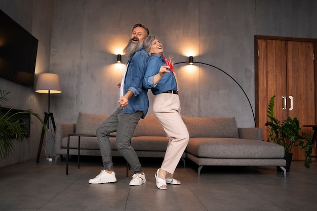 Free photo senior couple dancing at home