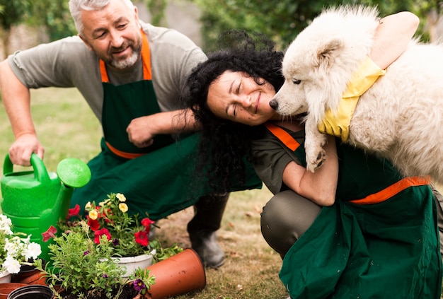 Free photo senior couple in garden with a dog