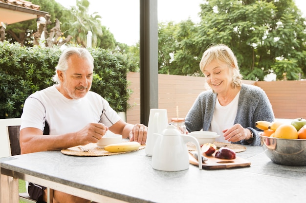 Senior couple having breakfast in garden