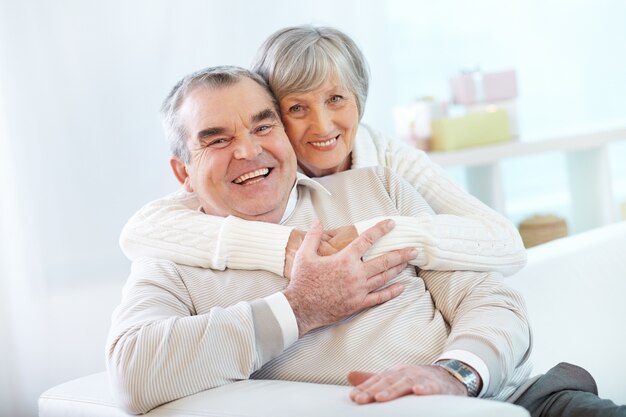 Senior couple hugging at home