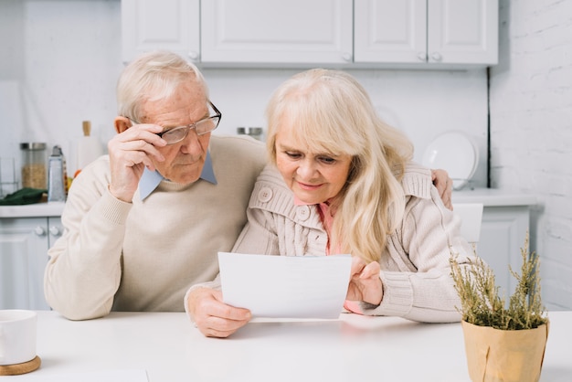 Free photo senior couple looking at paper