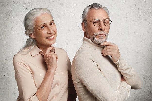 Senior couple in love stand close to each other. Elderly smiling woman with pleased expression