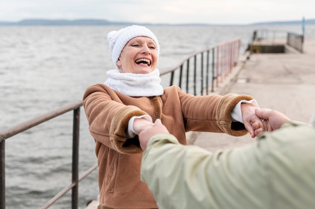 Free photo senior couple at seaside spinning