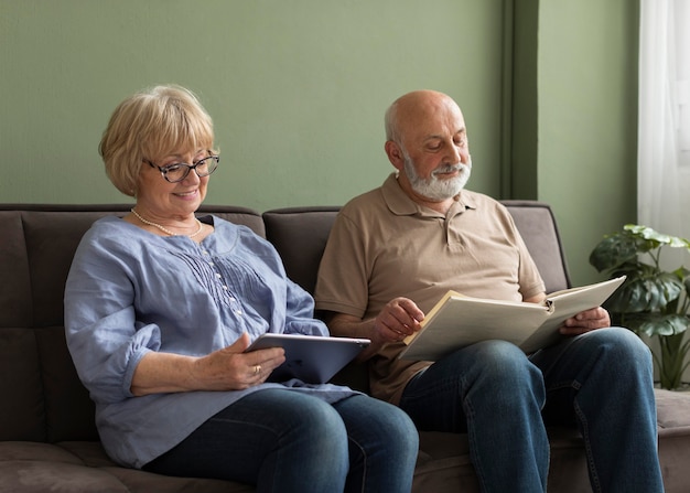 Senior couple with book and tablet