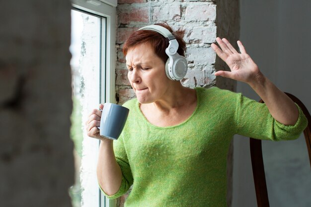 Senior female singing at coffee mug