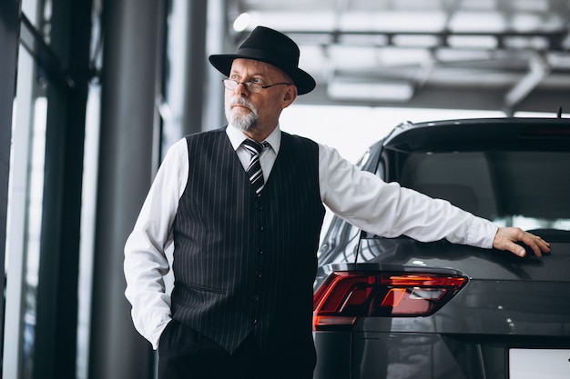 Senior man in a car showroom choosing a car