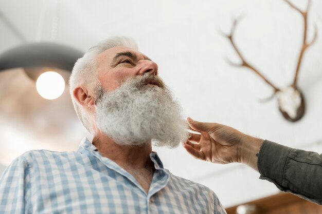 Senior man consulting on beard trimming in salon