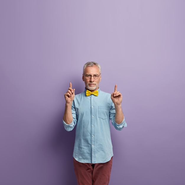 Free Photo senior man in denim shirt and yellow bowtie